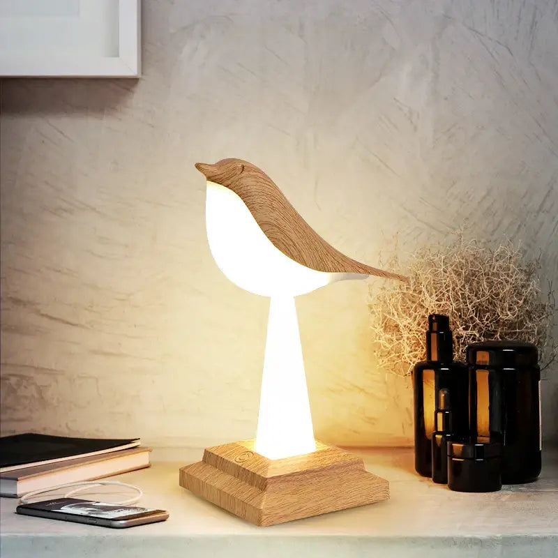 Modern gold and white wooden bird table lamp with warm glowing light and natural wood grain finish for desk decorbites bird table