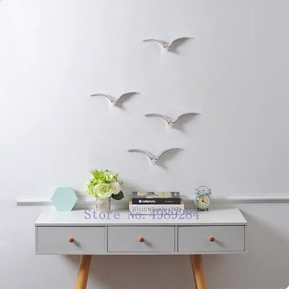 Silver metallic bird wall decor with sleek minimalist design complementing modern gold and white ceramic pendant wall decor
