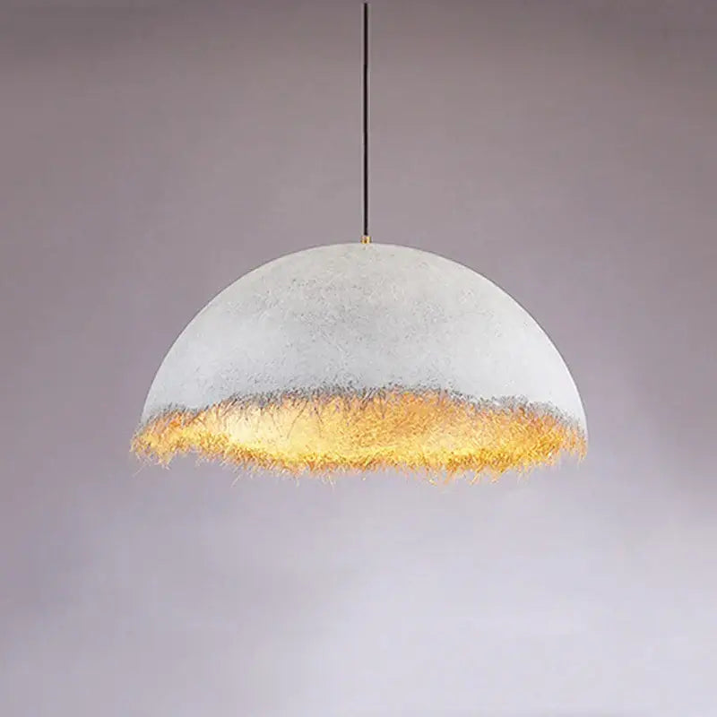 Modern gold white half nest pendant lamp with a textured white concrete dome and warm golden fiber fringe decorbites gold white