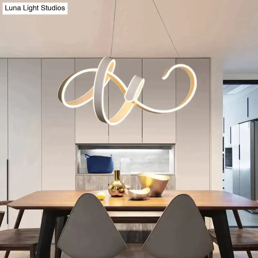 Modern gold and white led pendant lights with sleek intertwined rings suspended above a dining table