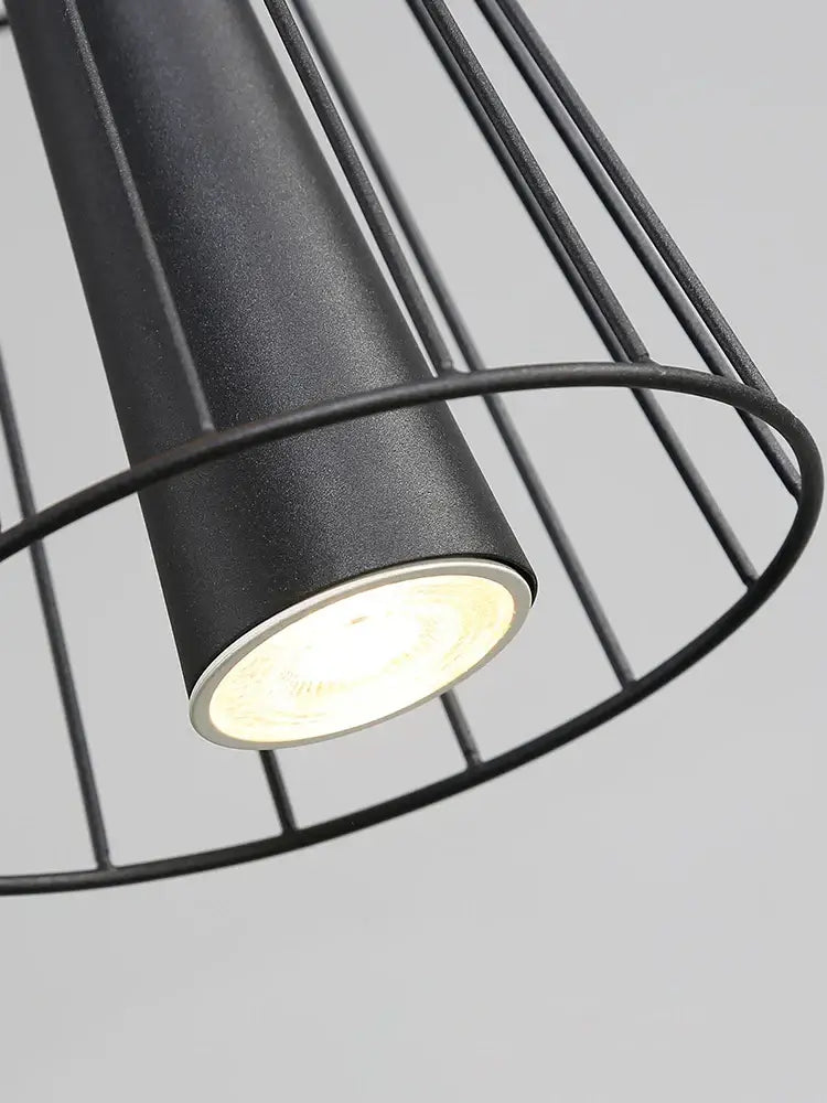 Black cylindrical gravity suspension lamp with matte finish and wire cage design for modern dining rooms