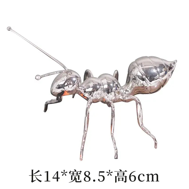 Modern golden ant metal sculpture featuring a shiny reflective silver finish and detailed segmented body for decorbites golden ant decor