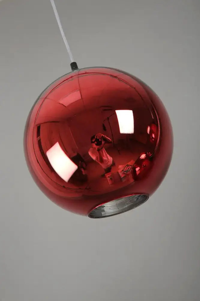 Glossy red spherical pendant light with a reflective surface and visible bulb from decorbites golden ball glass trio