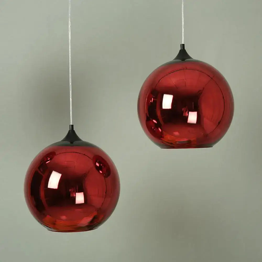 Two glossy red spherical pendant lights with black fixtures shown as part of decorbites golden ball glass pendant light collection