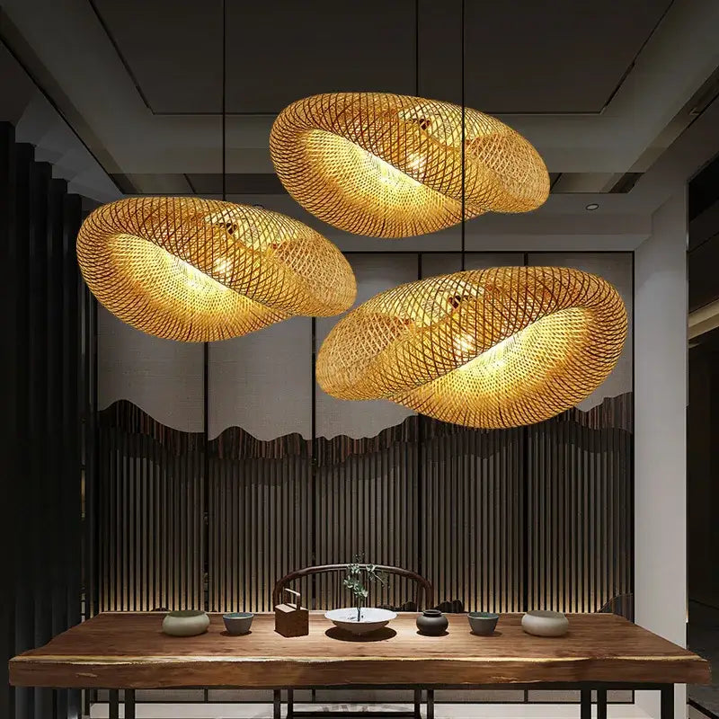 Three golden bamboo woven chandelier pendant lights hanging in a modern interior for tea room lighting