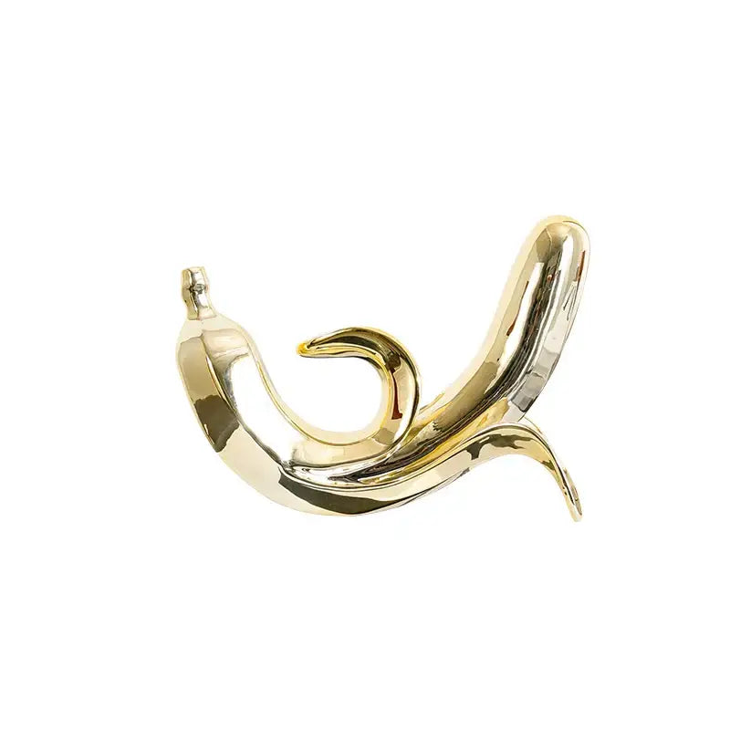 Modern golden banana figurine with smooth reflective surface and curved form for living room decoration