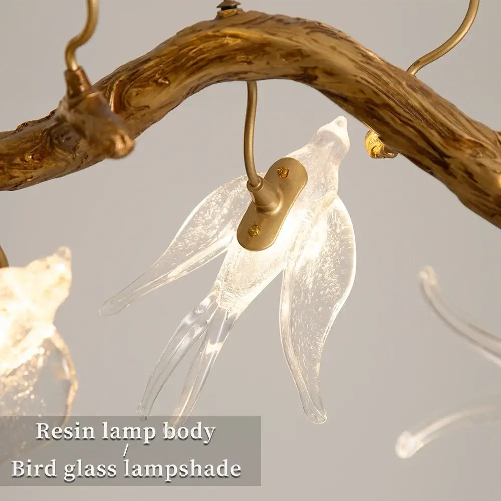 Modern golden bird crystal glass branch chandelier featuring clear glass lampshade resin body gold accents decorbites bird crystal