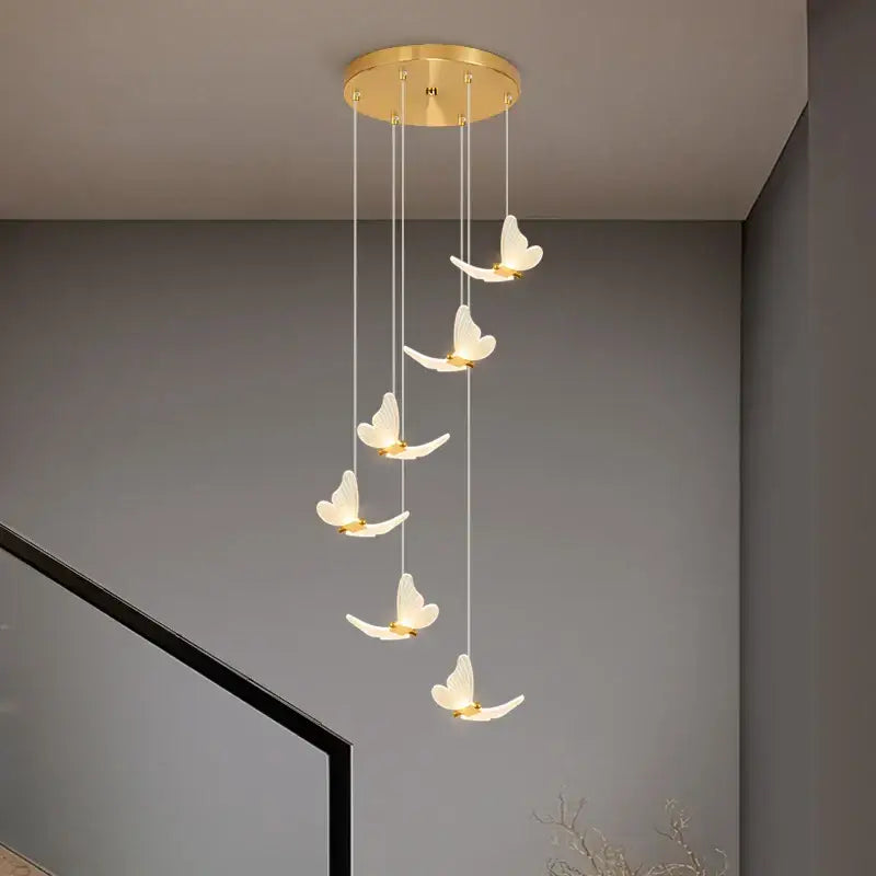 Modern golden butterfly led chandelier with five illuminated white butterfly pendants in gold decorbites golden butterfly style