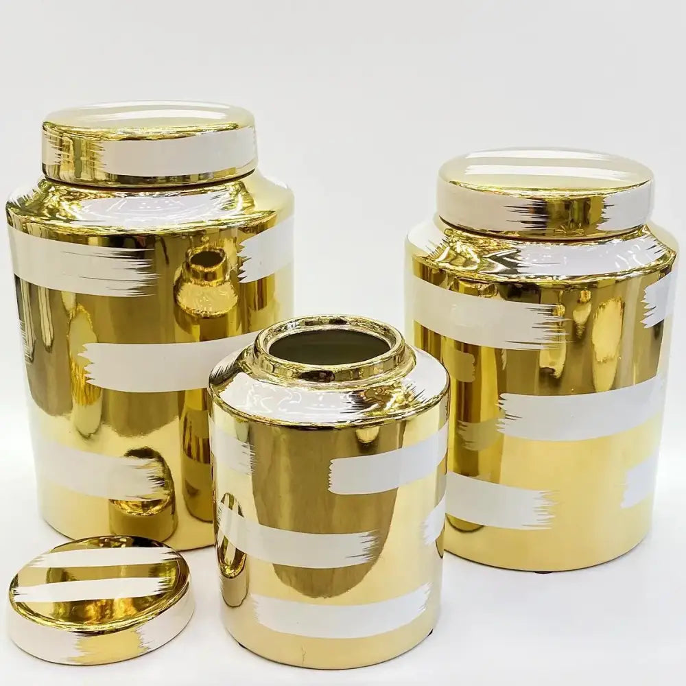 Set of three decorbites golden ceramic canisters with white stripes and brushed metallic finish for living room storage