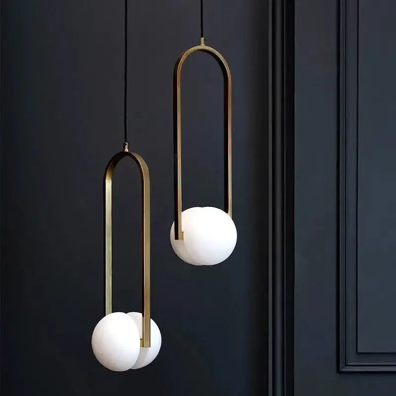 Modern brass pendant lights with frosted glass spheres feature sleek curved frames for dining room decorbites golden chandelier
