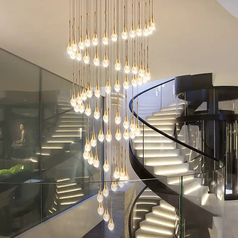 Modern golden crystal led staircase chandelier with teardrop fixtures housing glowing bulbs for lobby lighting decorbites crystal led