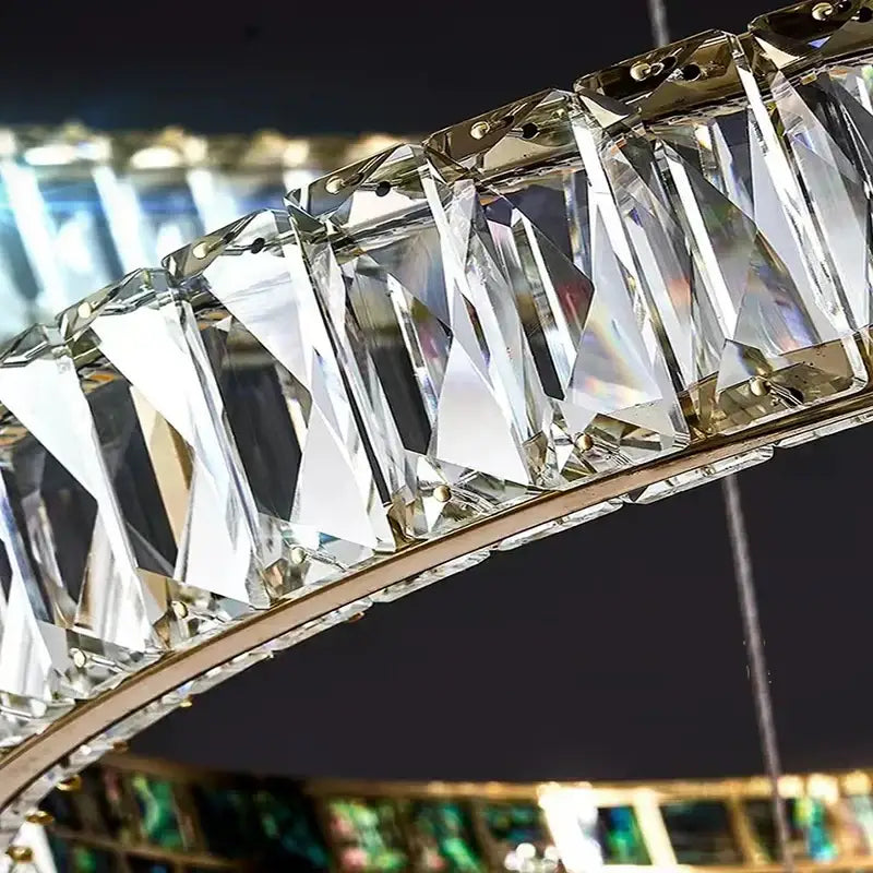A modern golden decorbites crystal ring ceiling chandelier with faceted crystal prisms in a polished metal frame