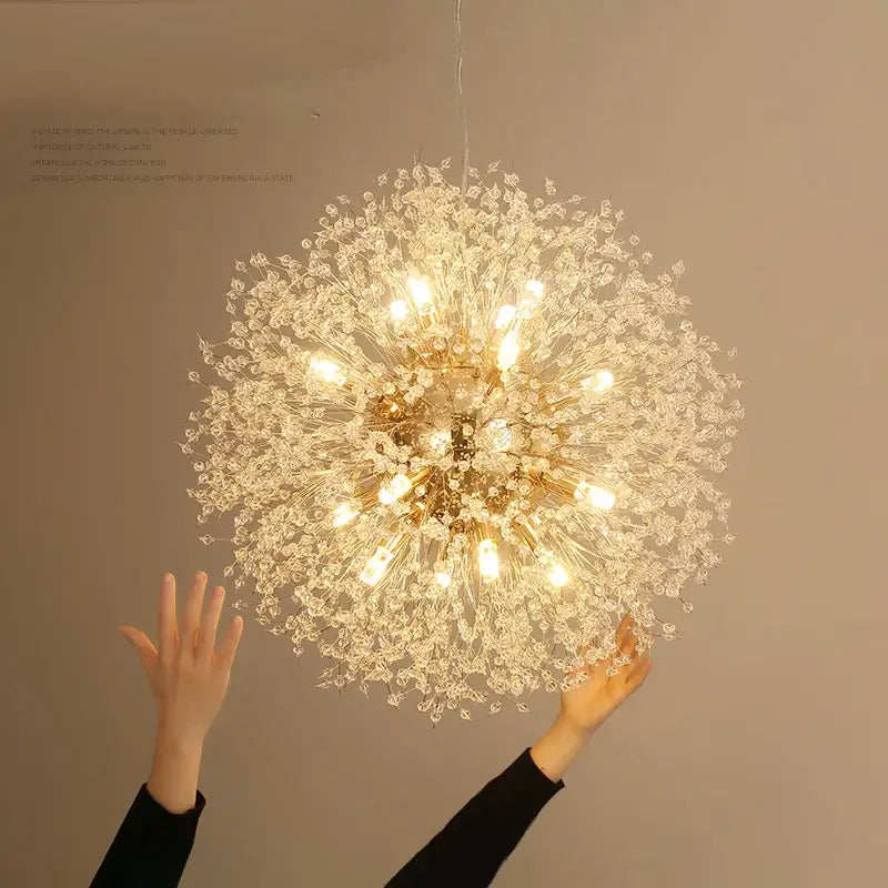 A modern golden dandelion spark led chandelier with clear crystal elements illuminated by warm lights for living rooms