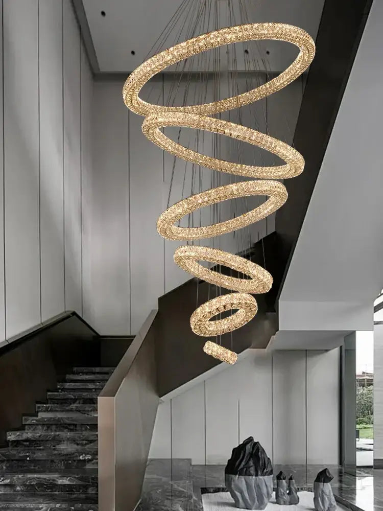 Modern golden decorbites crystal ring chandelier with spiral design and crystal accents hanging above staircase