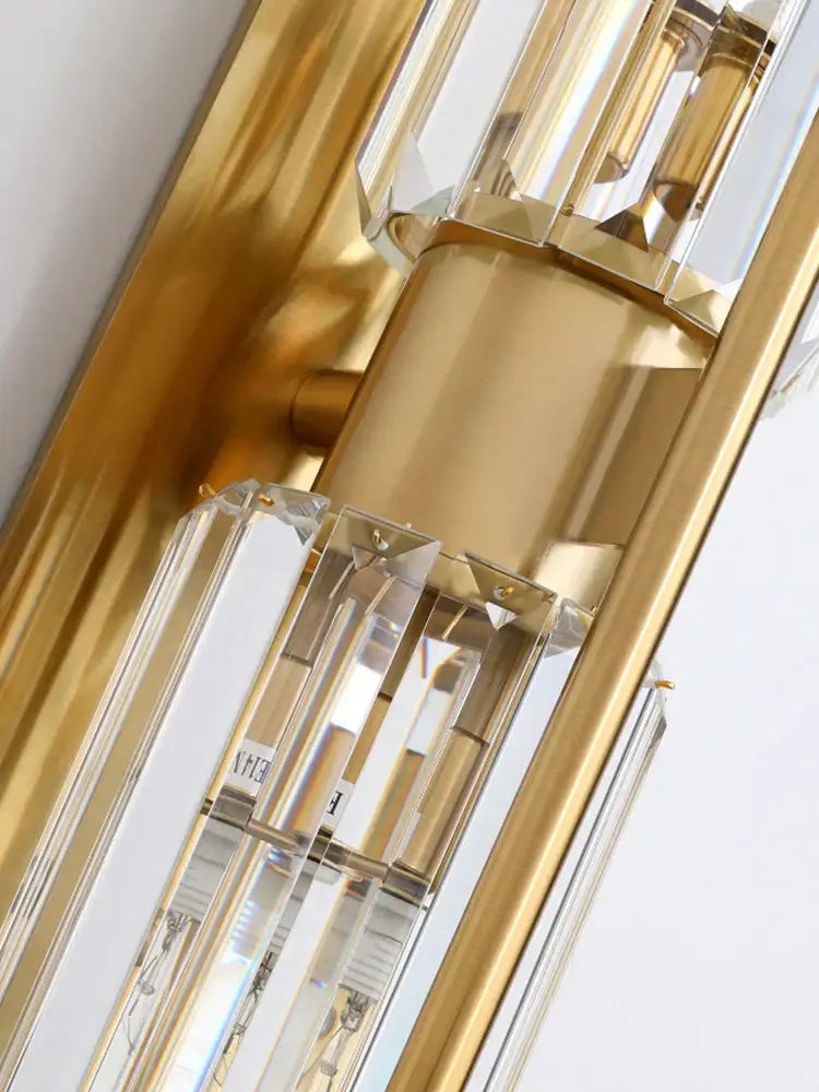 Modern golden decorbites crystal wall light with gold-toned chandelier and clear prisms for elegant bedroom decor