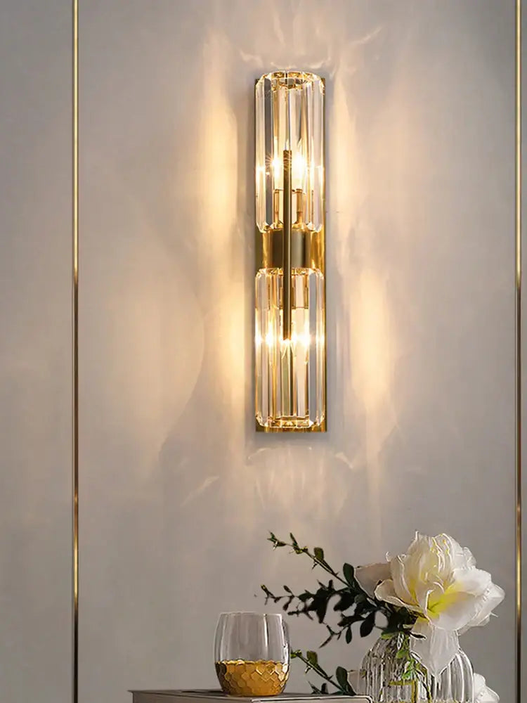 Modern golden decorbites crystal wall light featuring gold-toned vertical prisms and warm glowing lights for bedroom