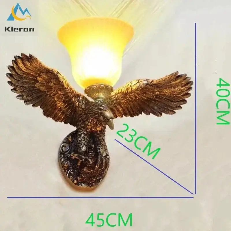 Modern golden eagle crystal led wall lamp in bronze with detailed feathers and warm yellow glass shade for living room