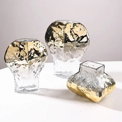 Three modern golden geometric glass vases with textured hammered finish and gold leaf accents for living room decor