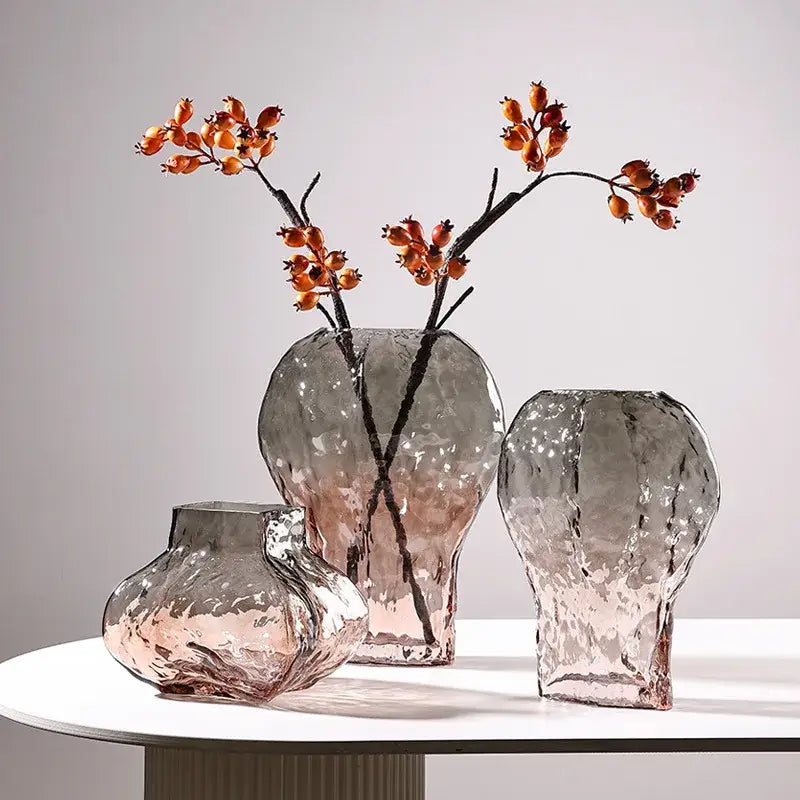 Three textured glass vases in gradient gray and pink hues complement decorbites golden geometric glass living room decor set