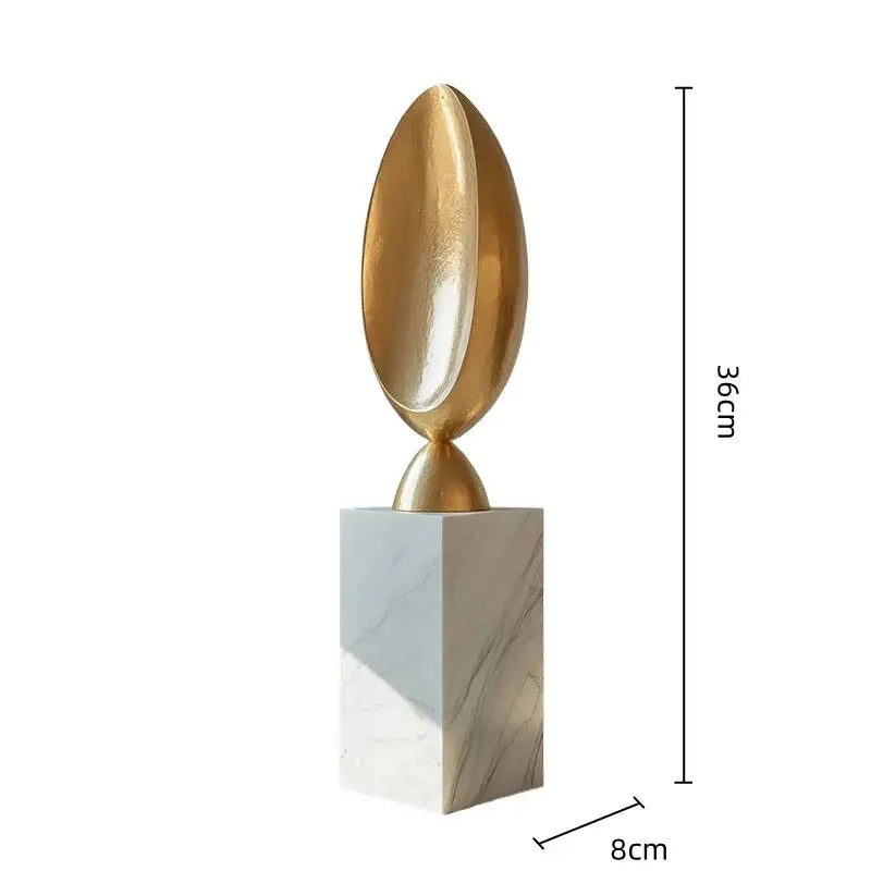 Modern golden geometric resin egg-shaped sculpture with metallic finish on white marble base for home decor