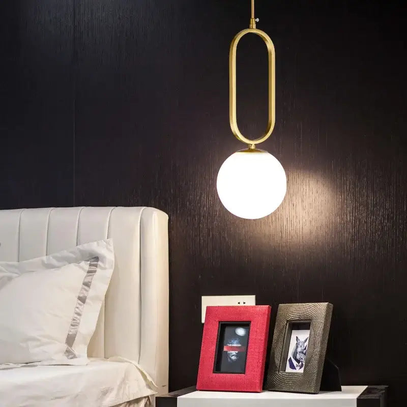 Modern golden glass ball pendant light with gold-toned oval metal frame and frosted glass globe by decorbites pendant light