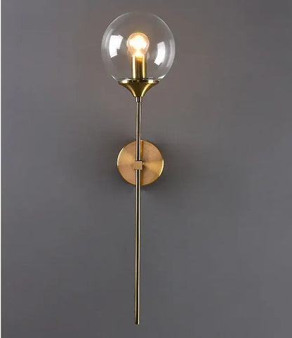 Modern golden glass ball wall lamp with brass finish and clear smoked glass globe featuring exposed bulb decorbites golden glass
