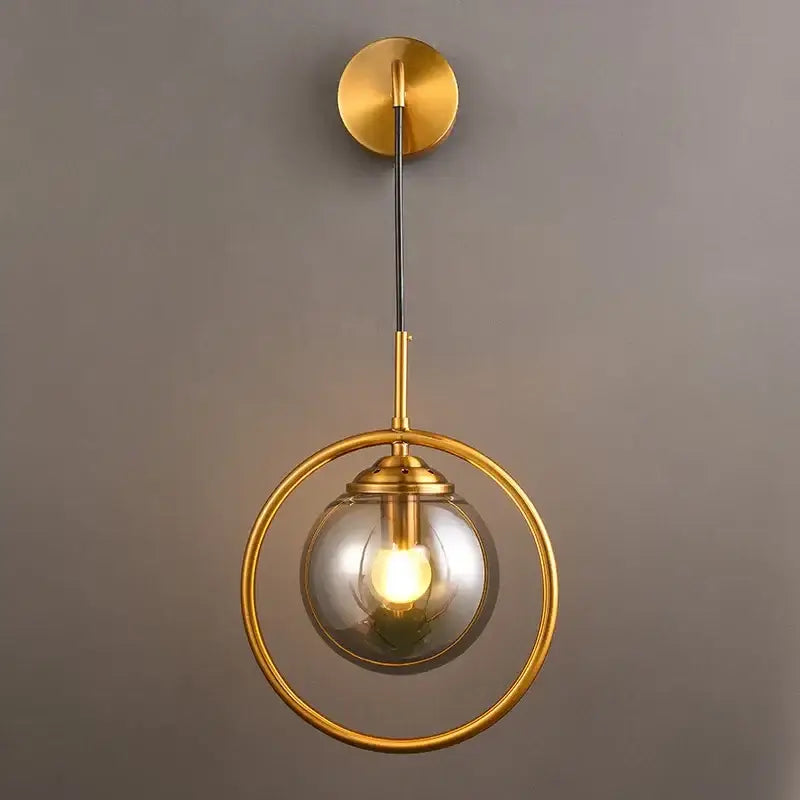Modern golden glass ball wall sconce with a gold-toned circular frame and clear glass globe for living room decorbites golden glass