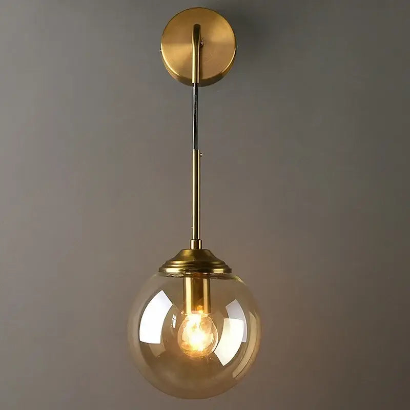 Modern golden glass ball wall sconce with a sleek brass finish and clear glass globe for stylish living room decorbites golden glass lighting