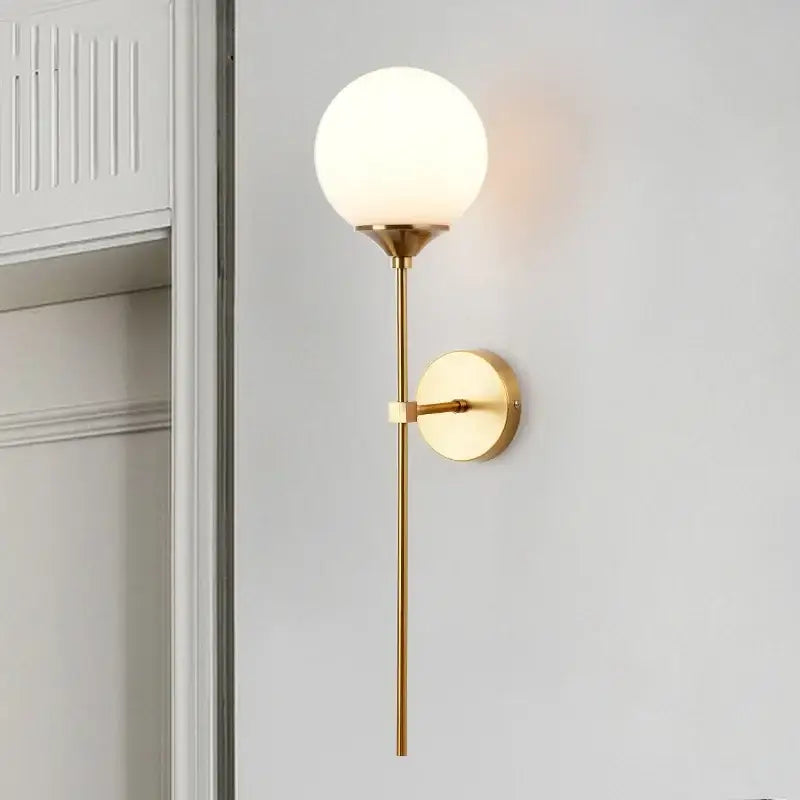 Modern golden glass ball wall sconce with gold-toned metal and frosted glass globe for decorbites golden glass decor