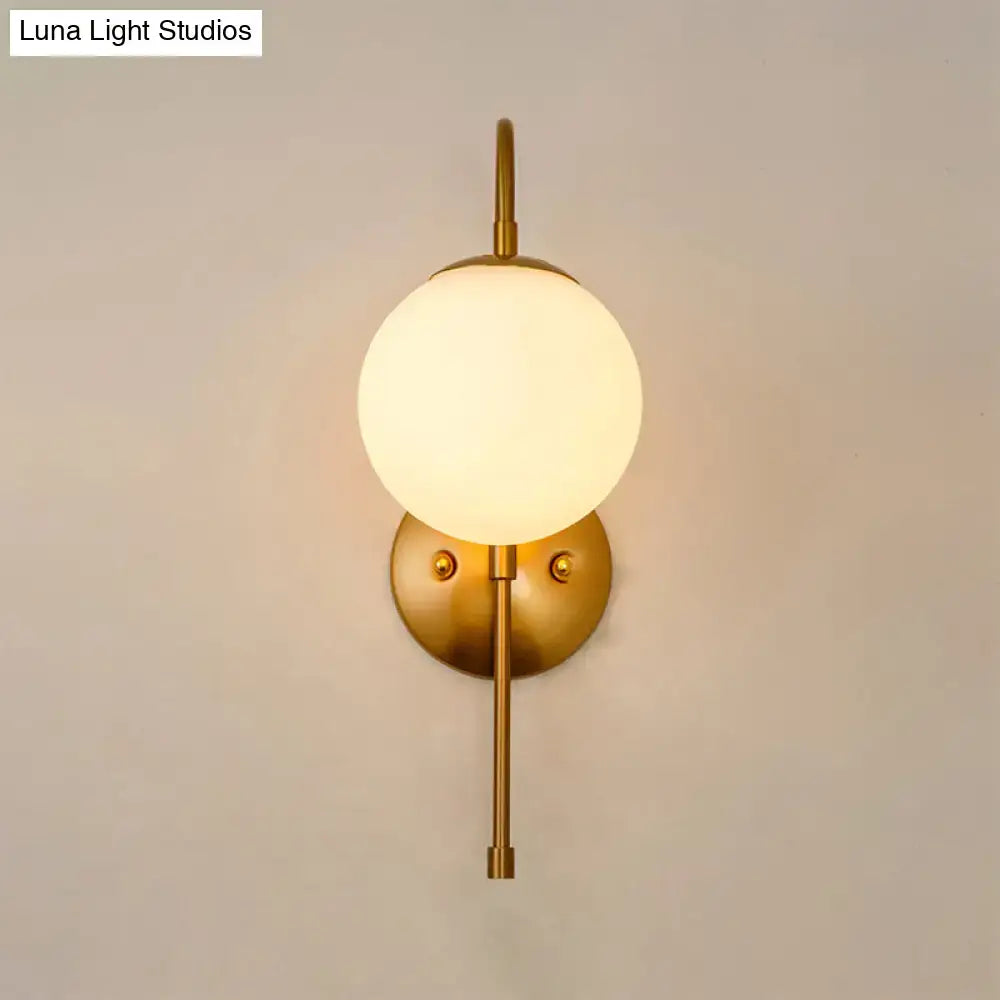 Modern golden gooseneck wall sconce with frosted glass ball shade and minimalist metal frame for bedroom lighting