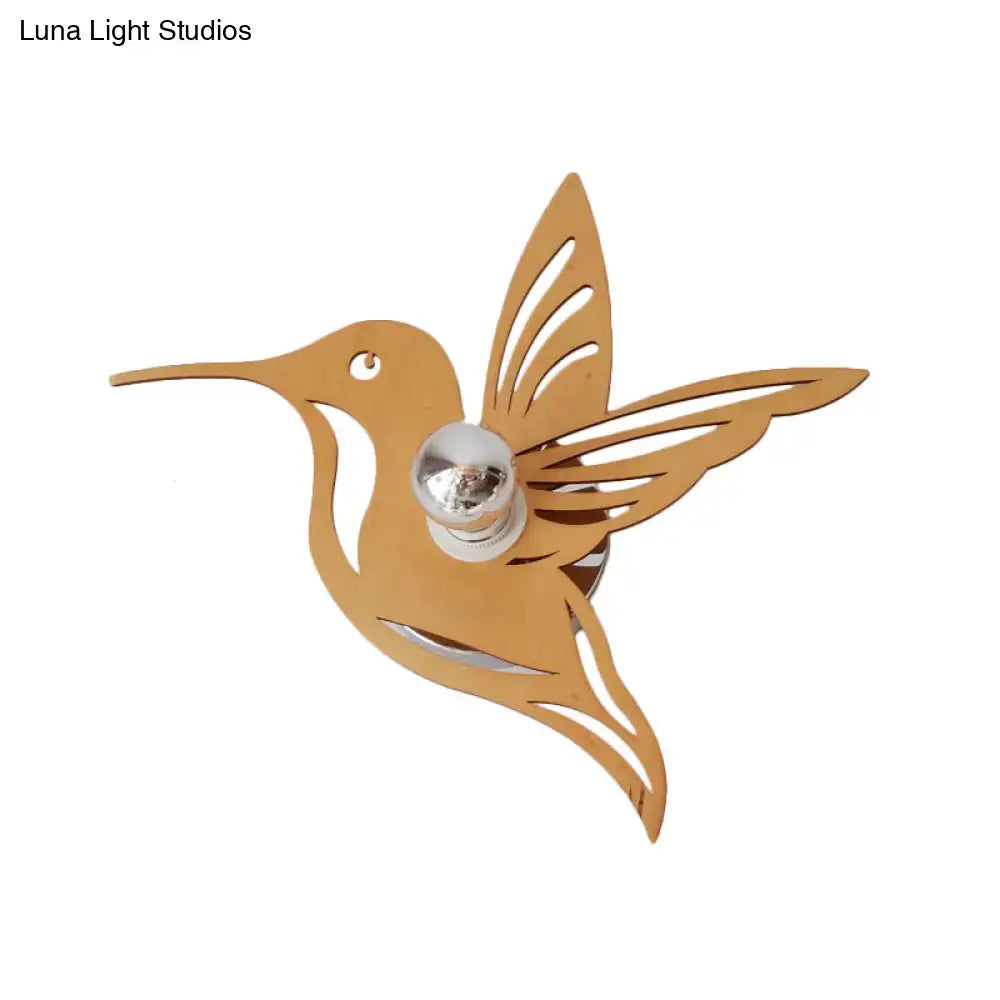 Modern golden hummingbird bedside lamp with polished silver bulb center in a gold inch wall-mounted fixture
