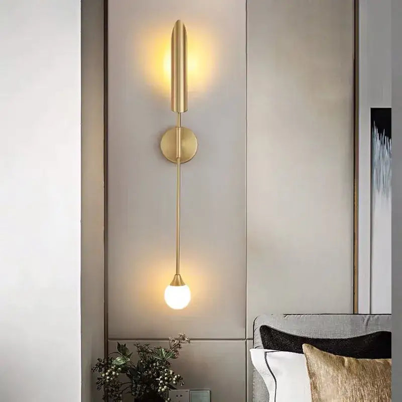 Modern golden inclined tube wall lamp with a gold-toned sleek cylindrical design and spherical bulb for luxury decorbites decor