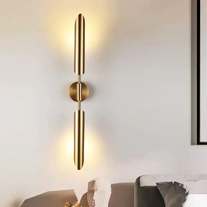 Modern golden inclined tube wall lamp with gold-toned cylindrical arms and central base for luxury living room decorbites