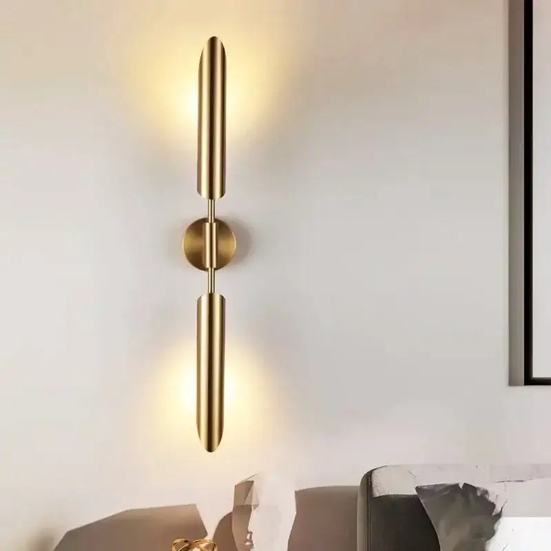 Modern golden inclined tube wall lamp featuring a gold-toned minimalist sconce with two vertical cylindrical arms by decorbites