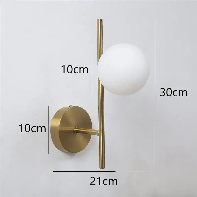 Modern golden indoor wall sconce with sleek vertical rod and frosted glass sphere ideal for indoor wall lights decorbites