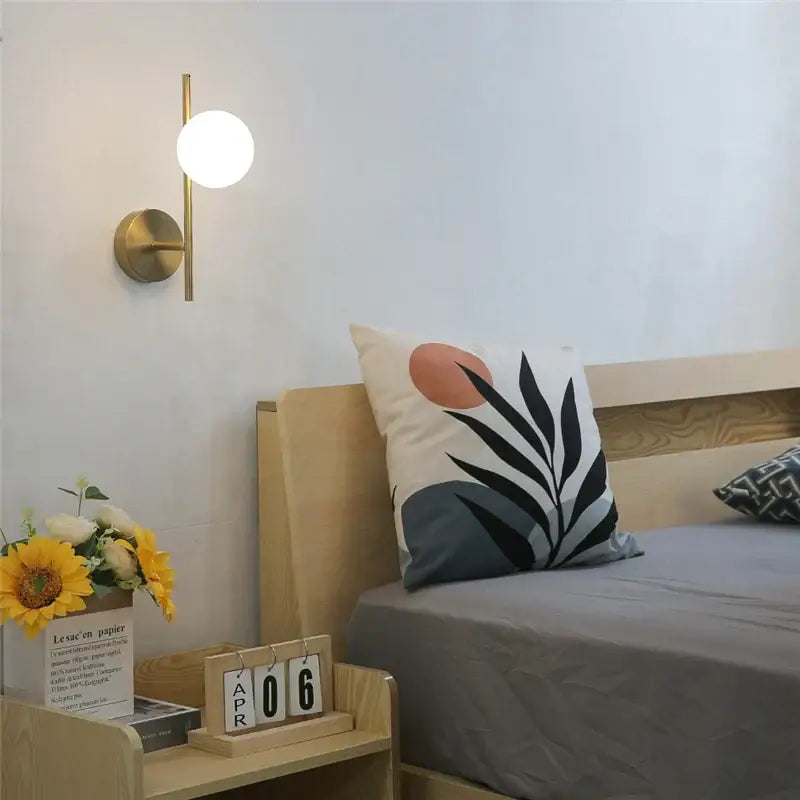 Modern brass wall sconce with spherical white glass shade by decorbites golden indoor wall lights for bedroom decor