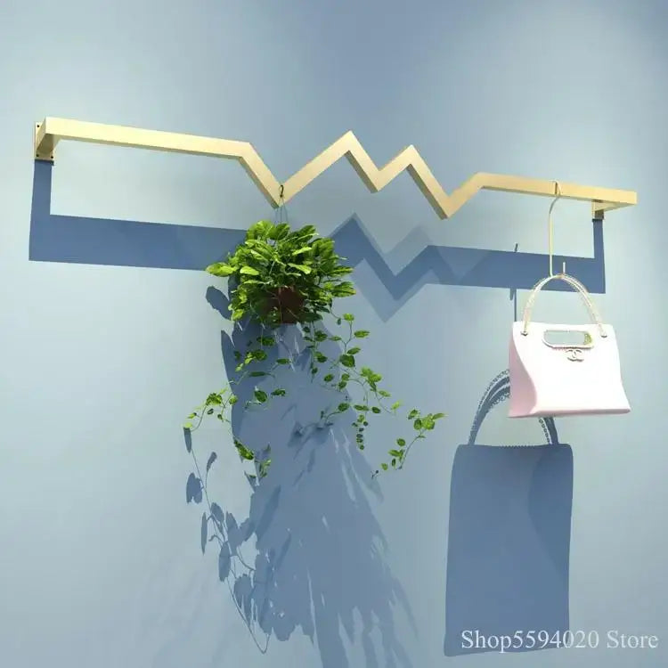 Modern decorbites golden iron ladder shelf with zigzag design holding handbag and potted plant for bedroom decor