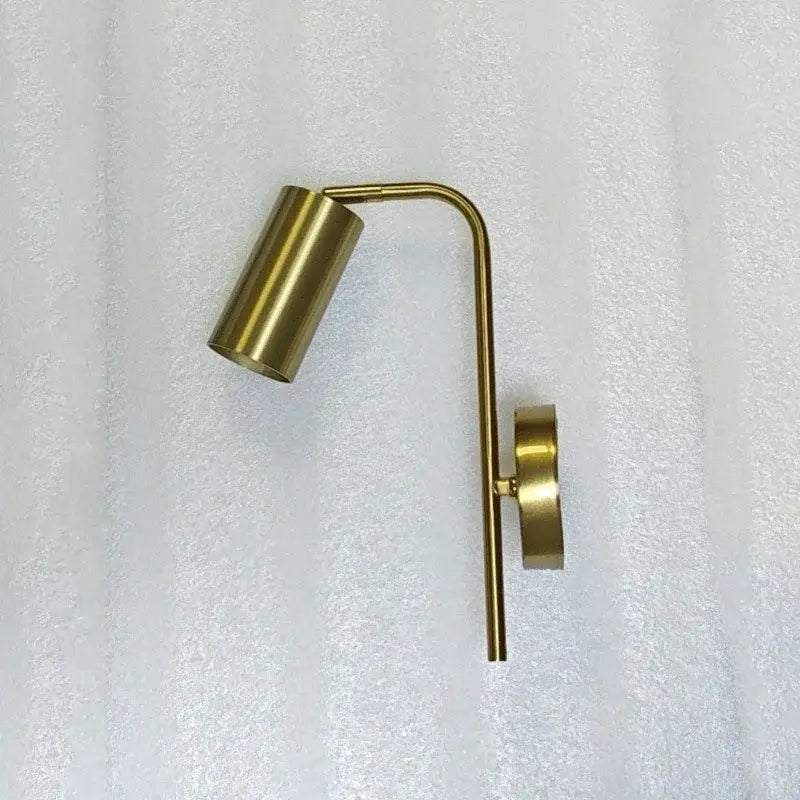 Modern brass-finished wall lamp with a curved arm and cylindrical head for decorbites golden led reading use