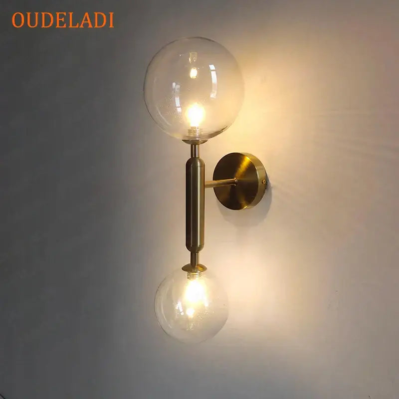 Modern golden led wall sconce with brass finish and two clear glass globe bulbs for bedroom decorbites golden led wall