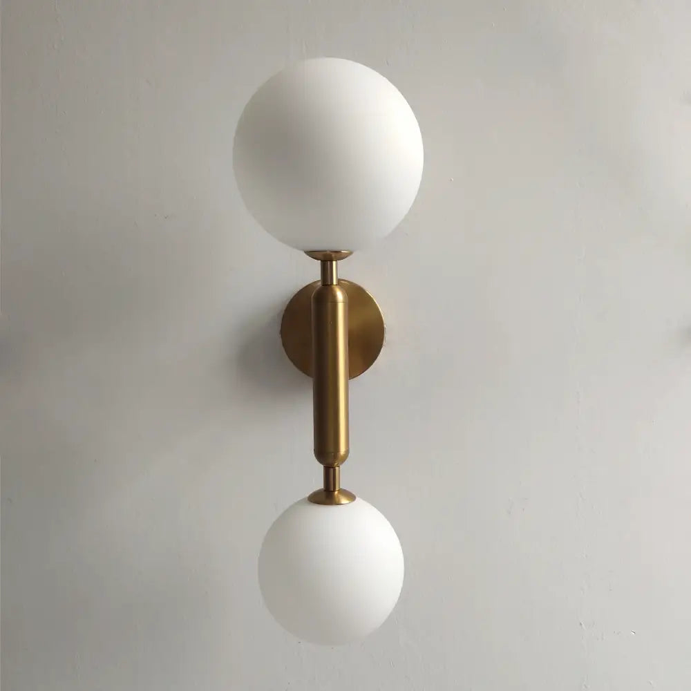 Modern golden led wall sconce with milky glass globes on polished brass stem for bedroom decorbites golden led wall