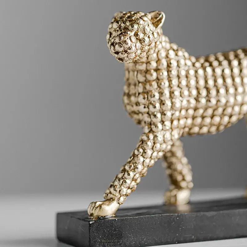 Golden leopard resin figurine with textured beaded surface on black base for modern living room decor by decorbites