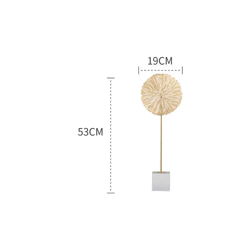 A gold-toned intricately textured metal golden lotus sculpture on a slender stem with square base for living room decor