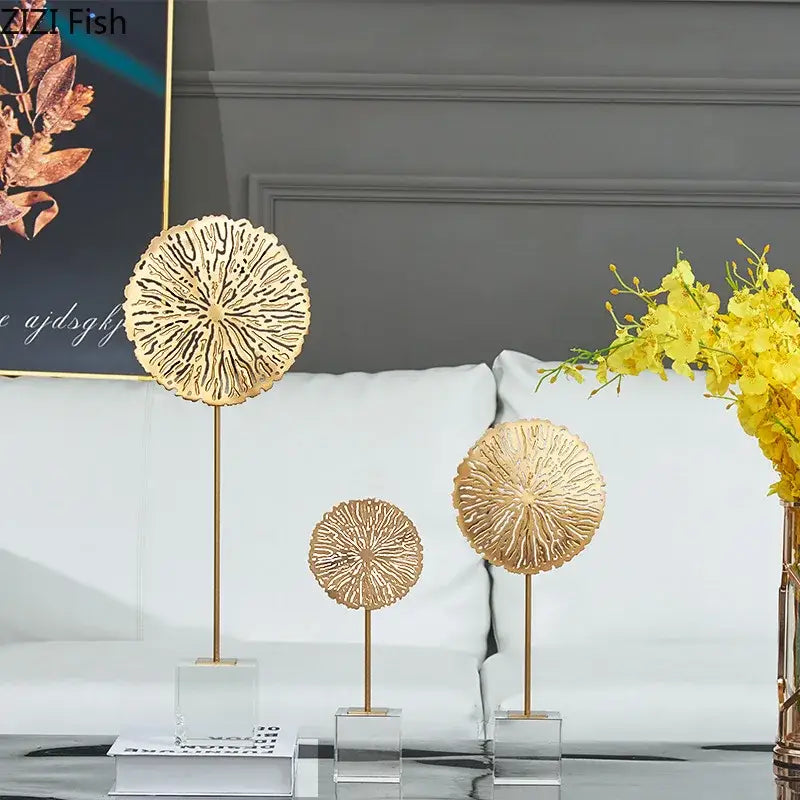 Three gold-toned circular metal golden lotus sculptures with intricate radial cutout patterns on slender stands for living room decor