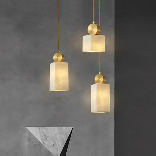 Three modern pendant lights with gold-toned metal fixtures and warm white shades for luxury marble pendant decorbites golden luxury