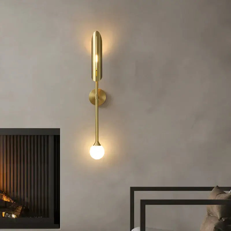Modern golden metal led wall lamps feature a gold-toned sleek cylindrical top and spherical bulb for bedroom decorbites decorbites golden metal wall lamps