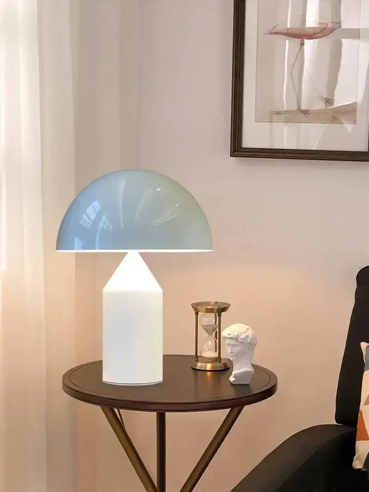 A modern decorbites golden mushroom led desk lamp with a translucent light blue dome and matte white base for reading light