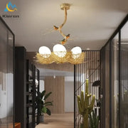 Modern golden nest glass led ceiling lamp featuring a bird-themed design with three white glass bulbs for living room decor