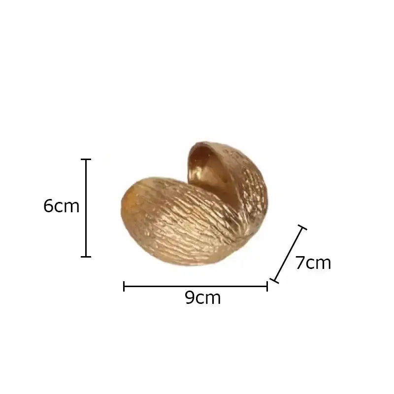 Modern golden nut shell ornaments desk decor featuring a textured glossy golden nut shell with spiral design