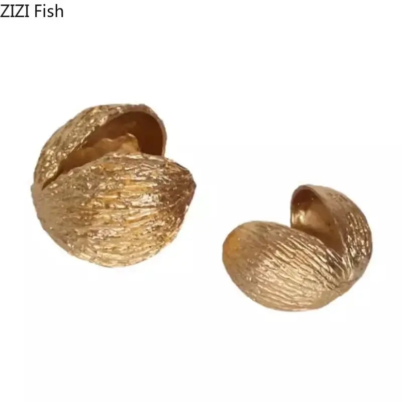 Modern golden nut shell ornaments with a textured metallic finish for living room desk decor by decorbites golden nut