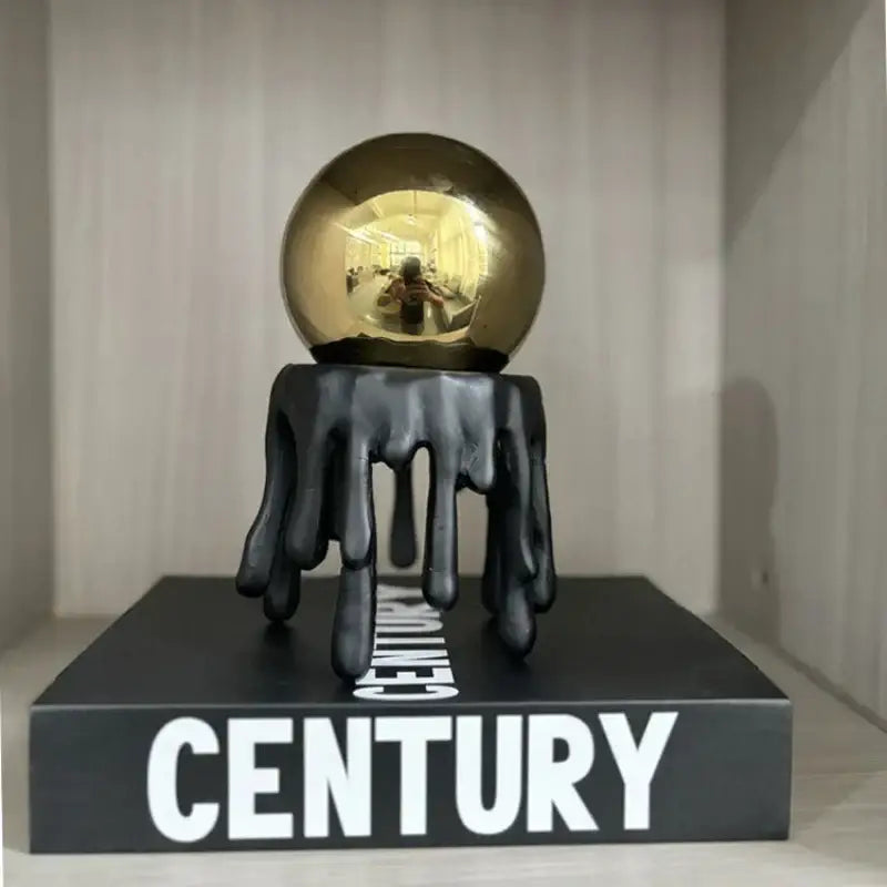 Shiny golden octopus spherical ornament resting on black dripping resin base modern decorbites golden octopus decor